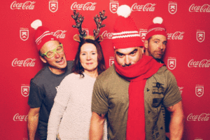 Gif of a 4 people dancing in front of the Coca-Cola Killington branded backdrop photo booth