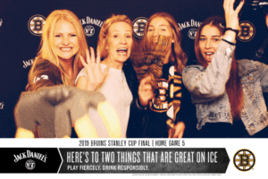 Gif of 4 women posing with Bruins props in the Jack Daniel's/Bruins branded backdrop photo booth