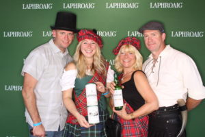 4 people posing with Whiskey at a Laphroaig Whiskey branded backdrop photo booth