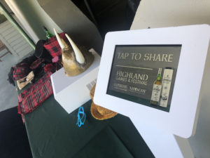 Social photo booth sharing tablet next to the table of Laphroaig Whiskey props