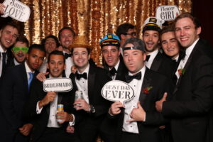 Large wedding party group in a open air photo booth holding and wearing props